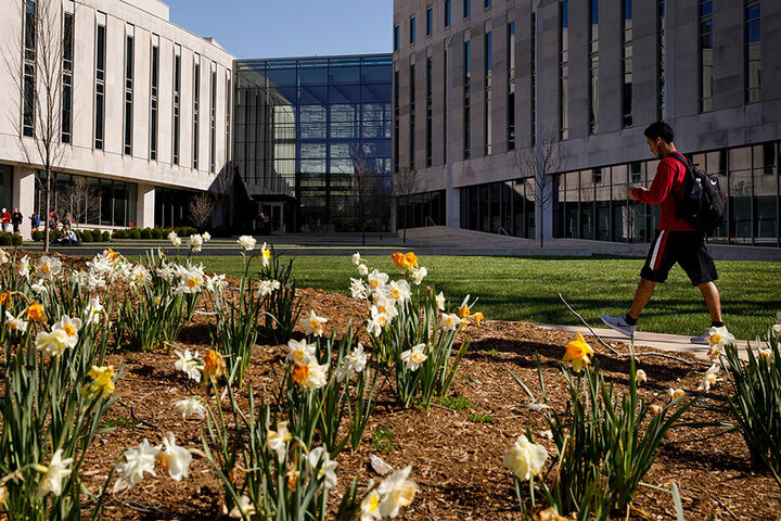 A male student walks in front of the Hamilton Lugar School.